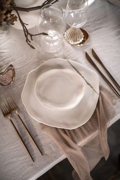 a white plate and silverware sitting on top of a table