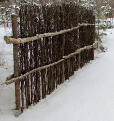 a fence made out of branches in the snow