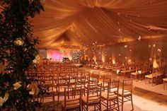 an indoor wedding venue set up with gold draping