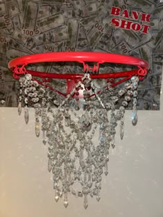 a red basketball hoop hanging from the side of a wall with money on it's back