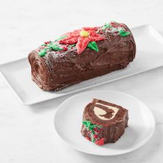 a piece of chocolate cake sitting on top of a white plate next to another piece of cake