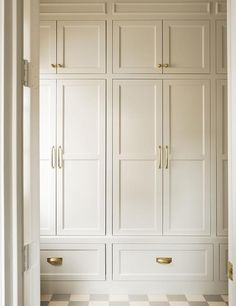 an open closet with white cabinets and checkered flooring