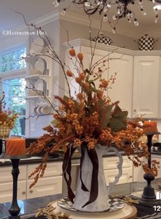 a vase filled with flowers sitting on top of a counter next to a candle holder