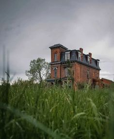 an old abandoned house sitting in the middle of tall grass