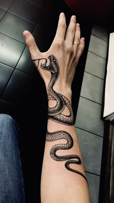 a person's arm with a tattoo on it that has a snake on it