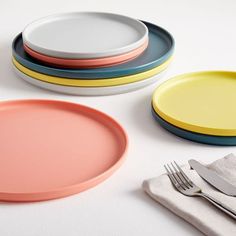 four plates and two forks on a white table