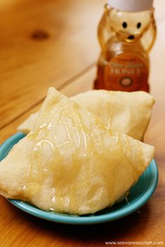 two dumplings on a blue plate next to a jar of peanut butter