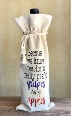 a bag with writing on it sitting on top of a wooden table next to an apple