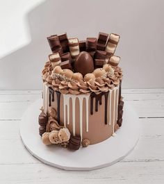 there is a chocolate cake with icing and decorations on the top, sitting on a white plate