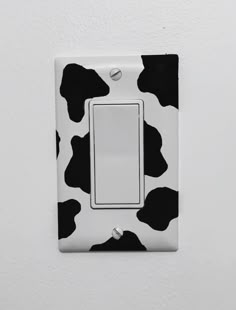 a black and white cow print light switch cover