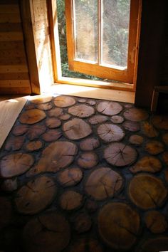 the floor is made out of logs in front of a window