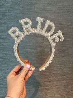 the bride tiara is being held by a woman's hand