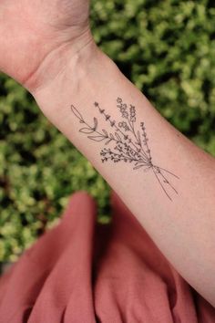 a woman's arm with a small tattoo design on the left side of her arm