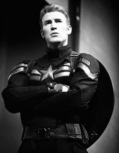 a man dressed as captain america standing with his arms crossed