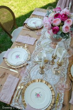 the table is set with pink and gold plates