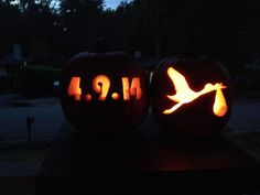 two carved pumpkins sitting on top of a table