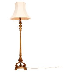 a floor lamp with a white shade on it's side and a cord attached to the base