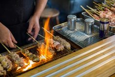 a man grilling skewers of food on an outdoor grill