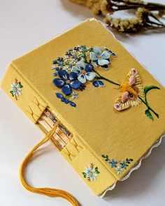 a yellow book with flowers and lace on it