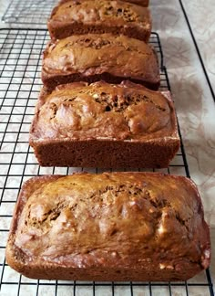 four loafs of banana bread cooling on a rack