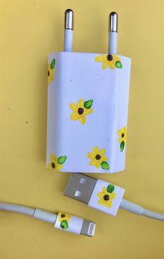 two yellow flowers are attached to an electrical outlet and plugged into a charger