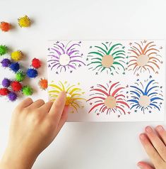 someone is cutting out some paper with colored pom poms