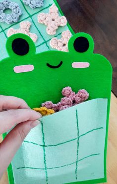 someone is holding a paper bag with some cereal in it and a frog on the inside