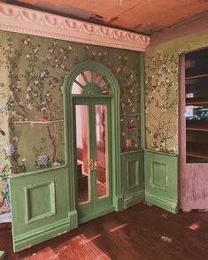 an empty room with green doors and floral wallpaper