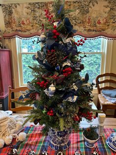 a christmas tree decorated with red, white and blue decorations on a dining room table