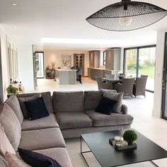 a living room filled with furniture next to a large open kitchen and dining room area