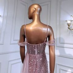 a mannequin wearing a pink sequin dress in front of a white wall