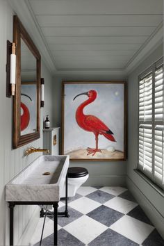 a bathroom with two paintings on the wall and a sink in the middle, along with a checkered floor