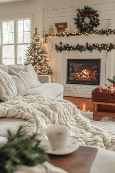 a living room decorated for christmas with white furniture and decorations on the fireplace mantel