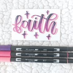 three black and pink pens sitting next to each other on top of a white surface