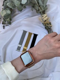 a person wearing an apple watch on their wrist with some flowers in front of them