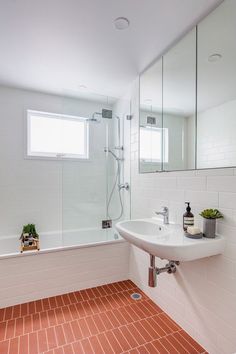 a bathroom with a sink, mirror and bathtub