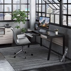 a desk with a computer on it in front of some windows and a potted plant