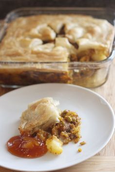 a piece of pie sitting on top of a white plate next to a casserole dish