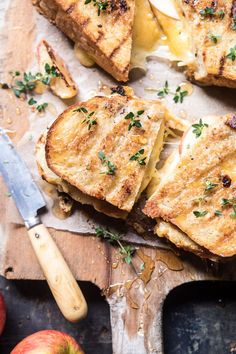 grilled cheese sandwiches on cutting board with apple slices and knife next to each other