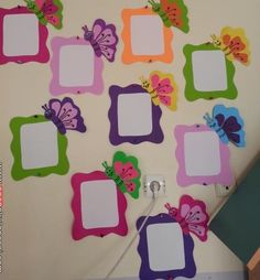 the wall is decorated with many different colored frames and butterflies on it, as well as a name tag