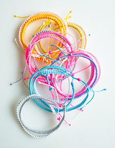 a pile of bracelets sitting on top of a white table