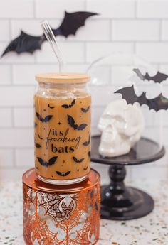 a jar filled with liquid sitting on top of a table next to a skeleton head