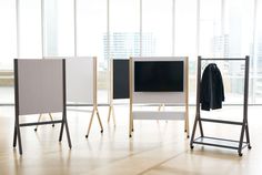 three different sized televisions sitting next to each other in an empty room with large windows