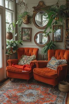 two orange chairs sitting next to each other on top of a rug in front of a window