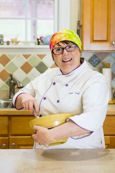 a woman in a chef's outfit is holding a bowl