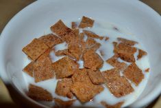 a bowl filled with cereal and milk on top of a table