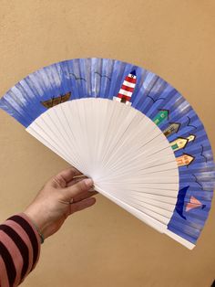 a hand holding a blue and white fan