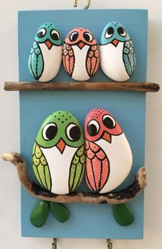 three painted birds sitting on top of a shelf