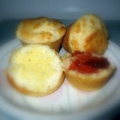 three small pastries on a plate with jam in the middle and another muffin