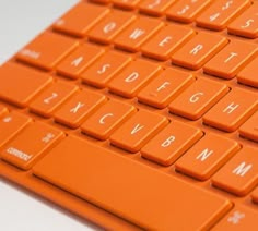 an orange computer keyboard sitting on top of a table